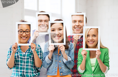 Image of friends or students covering faces with papers