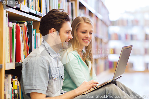 Image of happy students with laptop in library