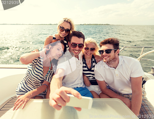 Image of smiling friends sitting on yacht deck