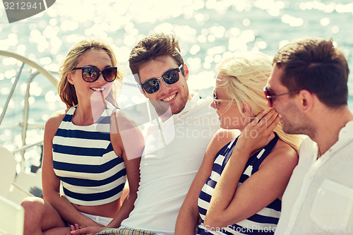 Image of smiling friends sitting on yacht deck