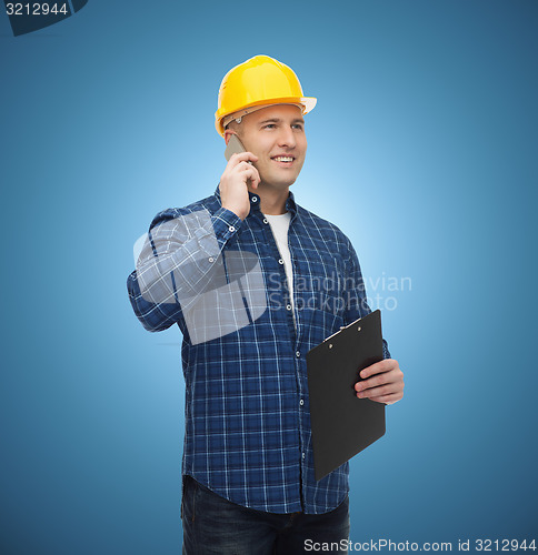 Image of smiling male builder in helmet with clipboard