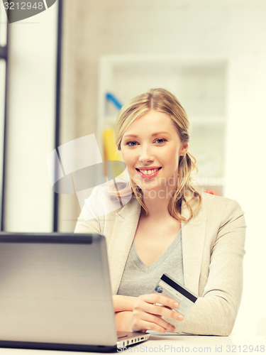 Image of happy woman with laptop computer and credit card