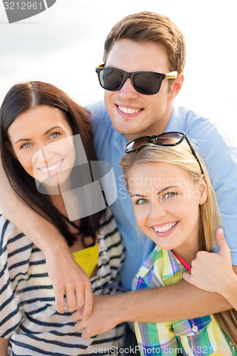 Image of group of happy friends hugging over sky background