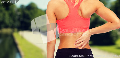 Image of close up of sporty woman touching her back