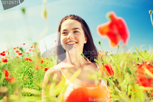 Image of smiling young woman on poppy field