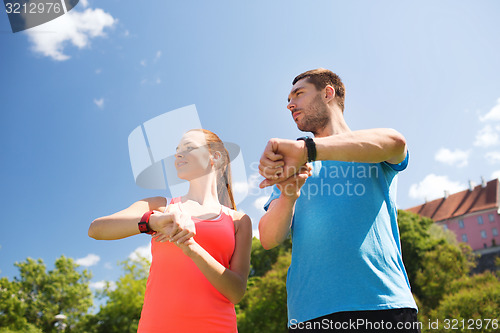 Image of smiling people with heart rate watches outdoors