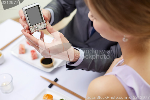 Image of close up of couple with camera at restaurant