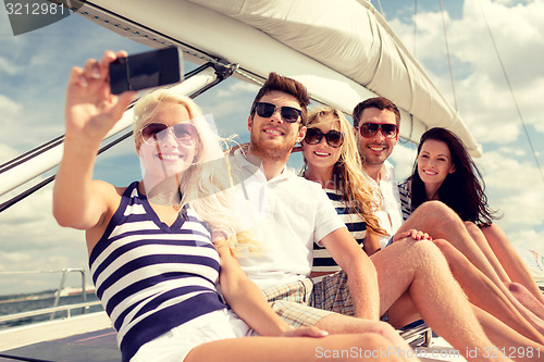 Image of smiling friends sitting on yacht deck