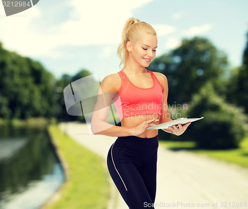 Image of smiling sporty woman with tablet pc computer