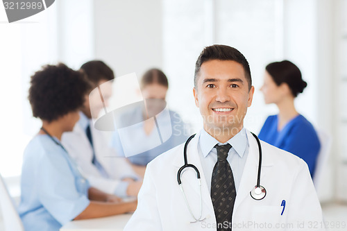 Image of happy doctor over group of medics at hospital