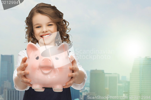 Image of happy girl holding piggy bank 