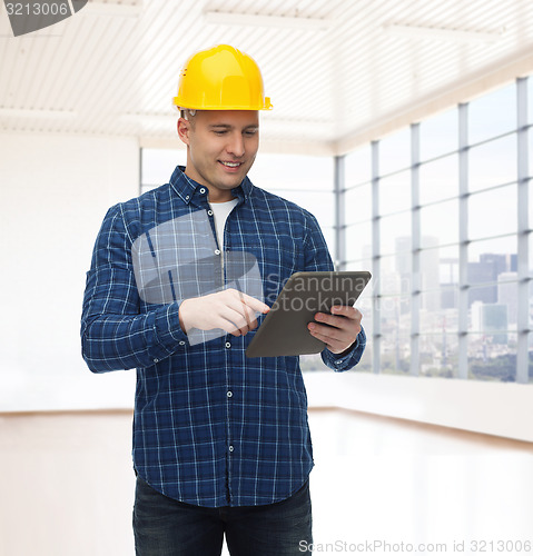 Image of smiling male builder in helmet with tablet pc