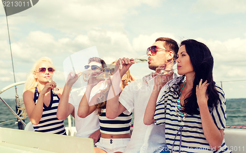 Image of smiling friends with glasses of champagne on yacht