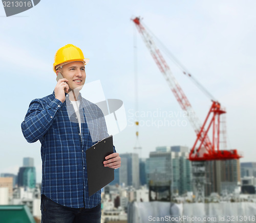 Image of smiling male builder in helmet with clipboard