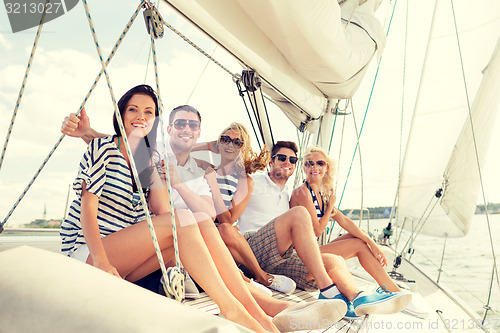 Image of smiling friends sitting on yacht deck