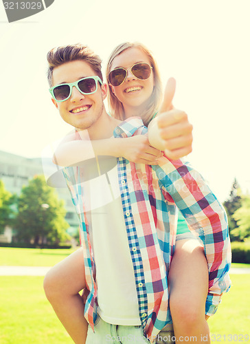 Image of smiling couple having fun and showing thumbs up