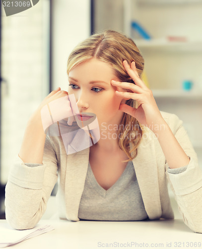 Image of bored and tired woman behind the table