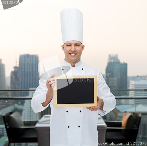 Image of happy male chef cook holding blank menu board