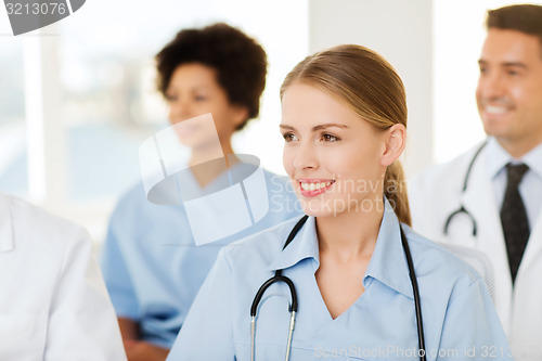 Image of happy doctor over group of medics at hospital