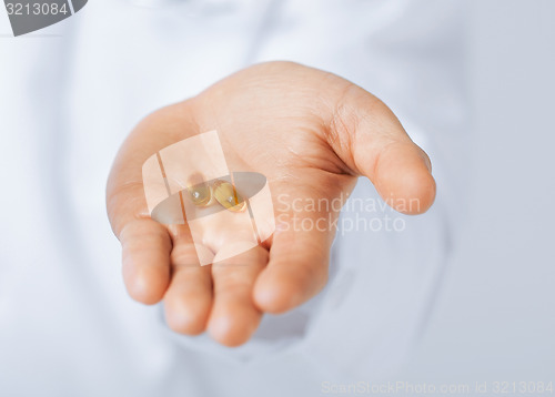 Image of doctor hands giving capsule and glass of water