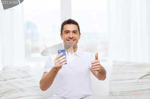 Image of happy man with smartphone at home