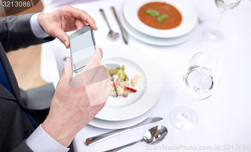 Image of close up of couple with smartphones at restaurant