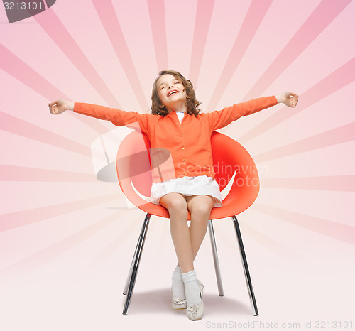 Image of happy little girl sitting on designer chair