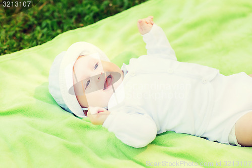 Image of smiling baby lying on floor and looking up