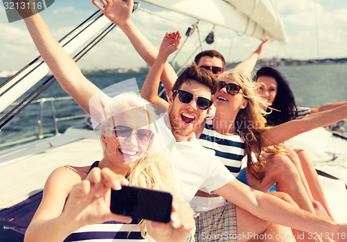 Image of smiling friends sitting on yacht deck