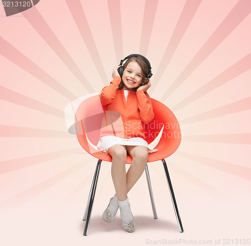 Image of happy little girl listening to music in headphones