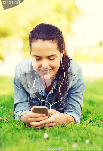 Image of smiling young girl with smartphone and earphones