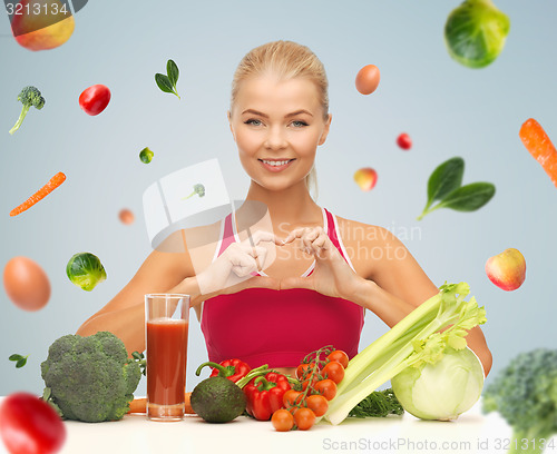 Image of happy woman with vegetarian food showing heart