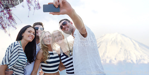 Image of friends taking selfie with smartphone