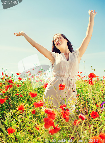 Image of smiling young woman on poppy field