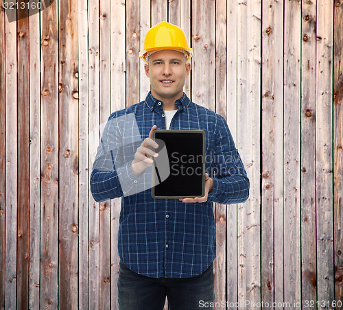 Image of smiling male builder in helmet with tablet pc