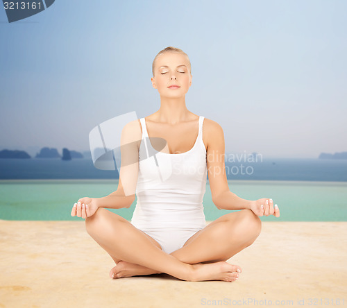 Image of woman  meditating in yoga lotus pose 