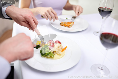 Image of close up of couple eating appetizers at restaurant