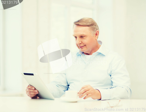 Image of old man with tablet pc computer at home