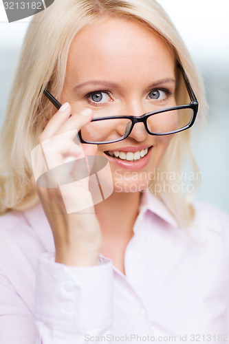 Image of smiling businesswoman or secretary in office