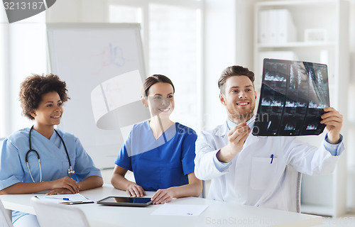 Image of group of happy doctors discussing x-ray image