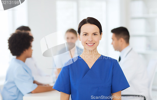 Image of happy doctor over group of medics at hospital