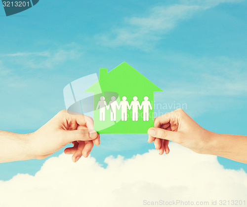 Image of man and woman hands with paper house