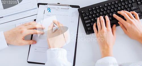 Image of doctor and nurse writing prescription paper