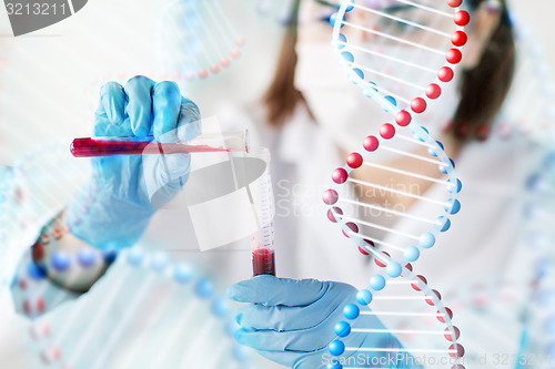 Image of close up of scientist with tube making test in lab