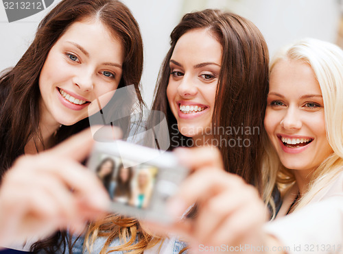 Image of beautiful girls taking selfie in the city
