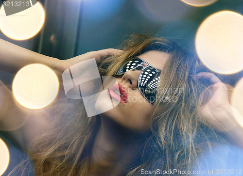 Image of beautiful woman in sunglasses in elevator