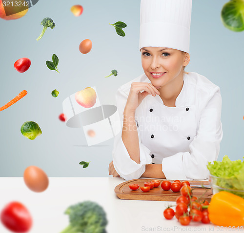 Image of smiling female chef with vegetables