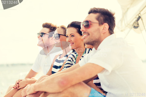 Image of smiling friends sitting on yacht deck