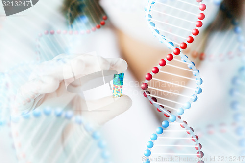 Image of close up of scientist holding pill in lab