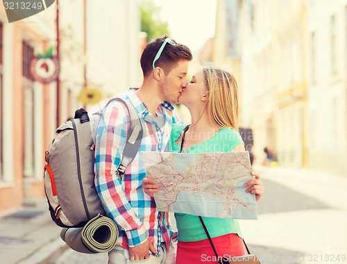 Image of smiling couple with map and backpack in city